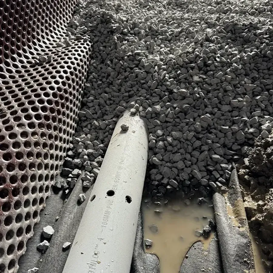 Drain perforé certifié BNQ dans la pierre nette, au pied du mur