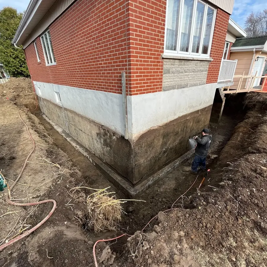 Fondation dégagée jusqu’à la semelle le long d’une maison de brique